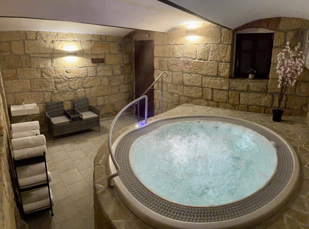 Private jacuzzi with massage jets in the natural sandstone wellness interior at the Resort Mezná, ideal for relaxation and regeneration after an active day in Bohemian Switzerland.